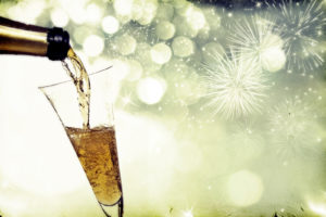 Vintage photo of pouring champagne against holiday lights